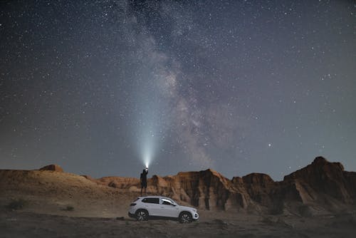 Person, Die Während Der Nacht In Der Nähe Des Fahrzeugs Steht