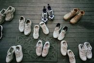 Various pairs of sneakers neatly laid out on a wooden deck, showcasing different styles.