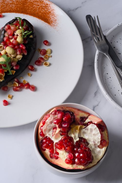 Free Top view of gourmet eggplant dish with pomegranate on a marble surface. Stock Photo