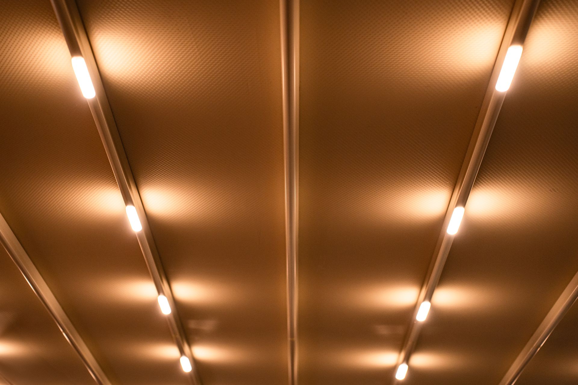 A minimalist ceiling with linear lights emitting a warm and inviting glow, creating a modern ambiance.