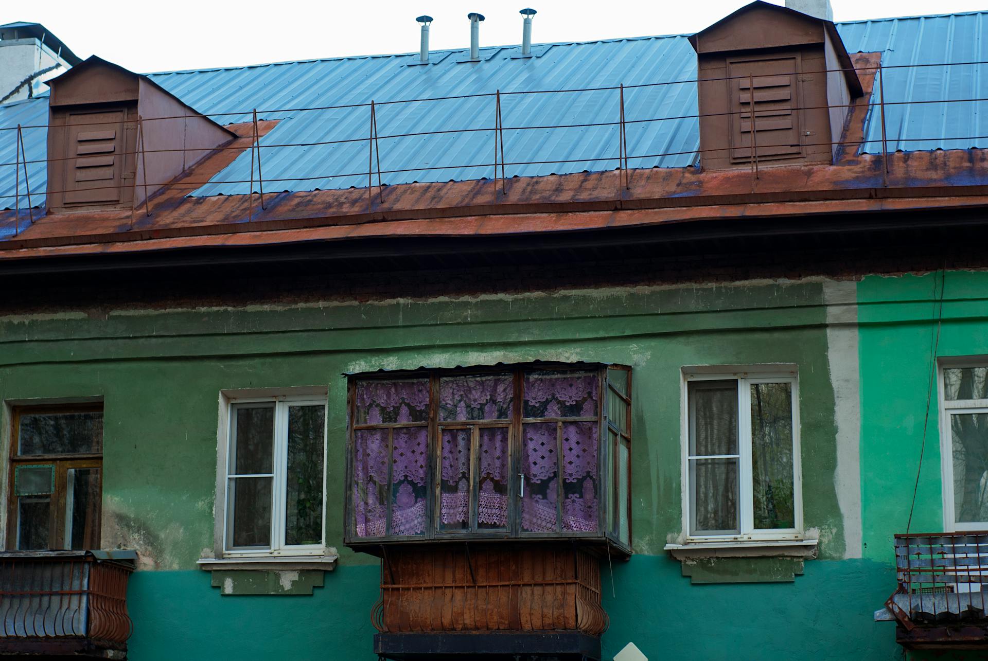 Close-up of a colorful old building facade with uniquely decorated windows.