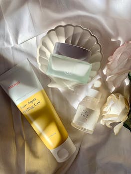 Stylized skincare products arrangement with soft lighting and flowers.