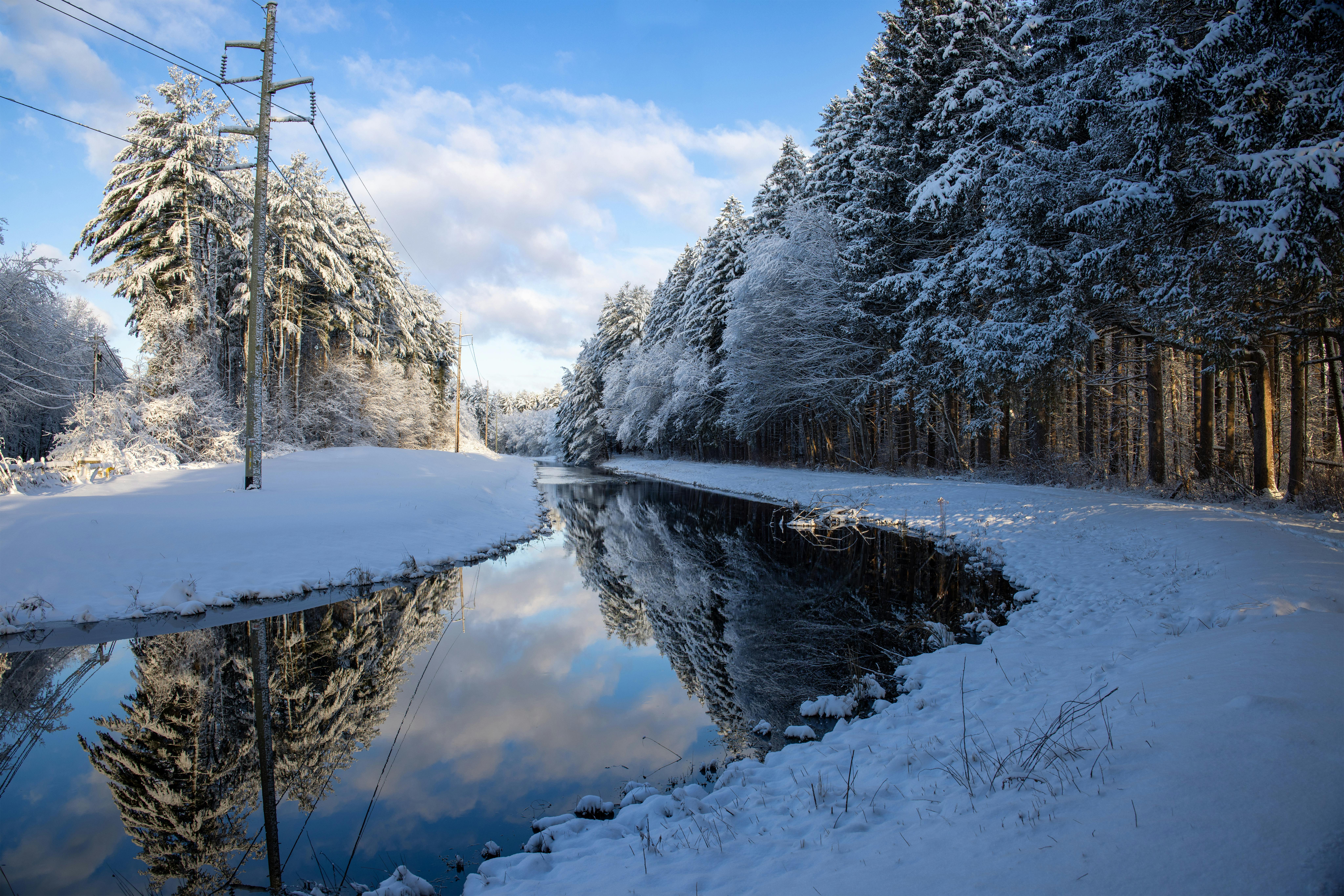 Serene winter landscape with snow-covered trees and reflected creek in Southborough, MA.