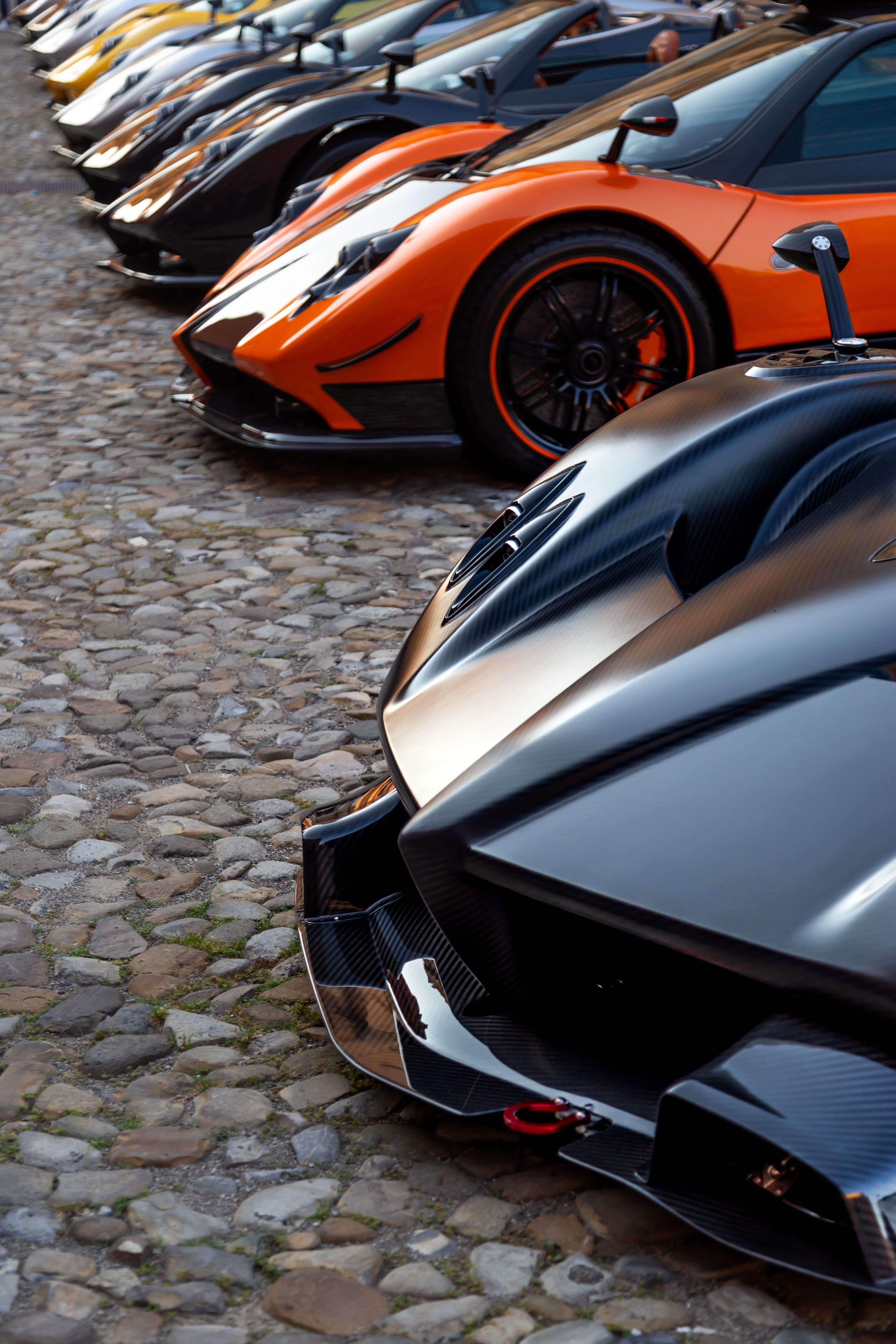 Lineup of Exotic Supercars on Cobbled Street · Free Stock Photo