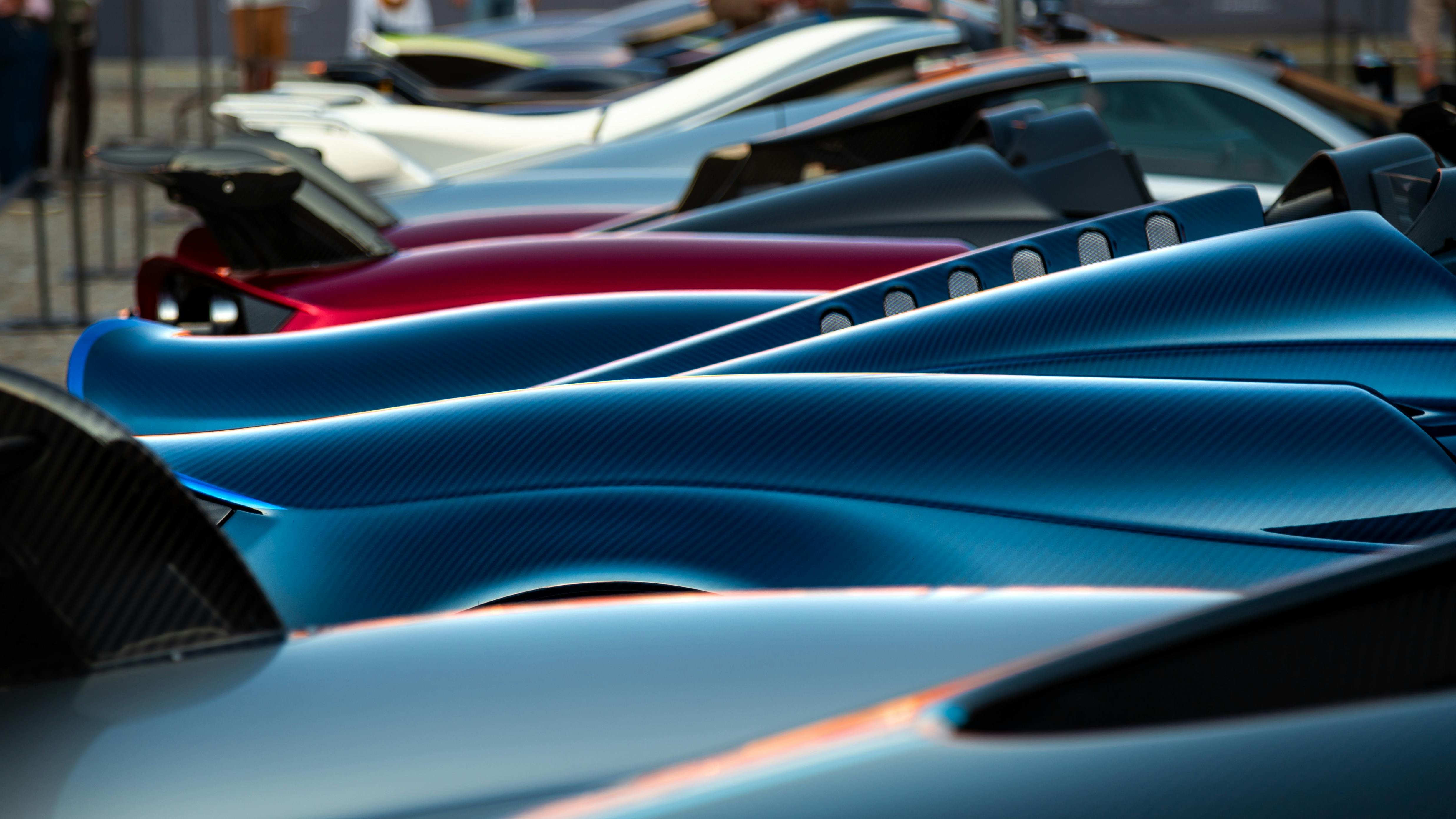 A stunning display of sleek hypercars showcasing premium designs and vibrant colors at an exhibition.