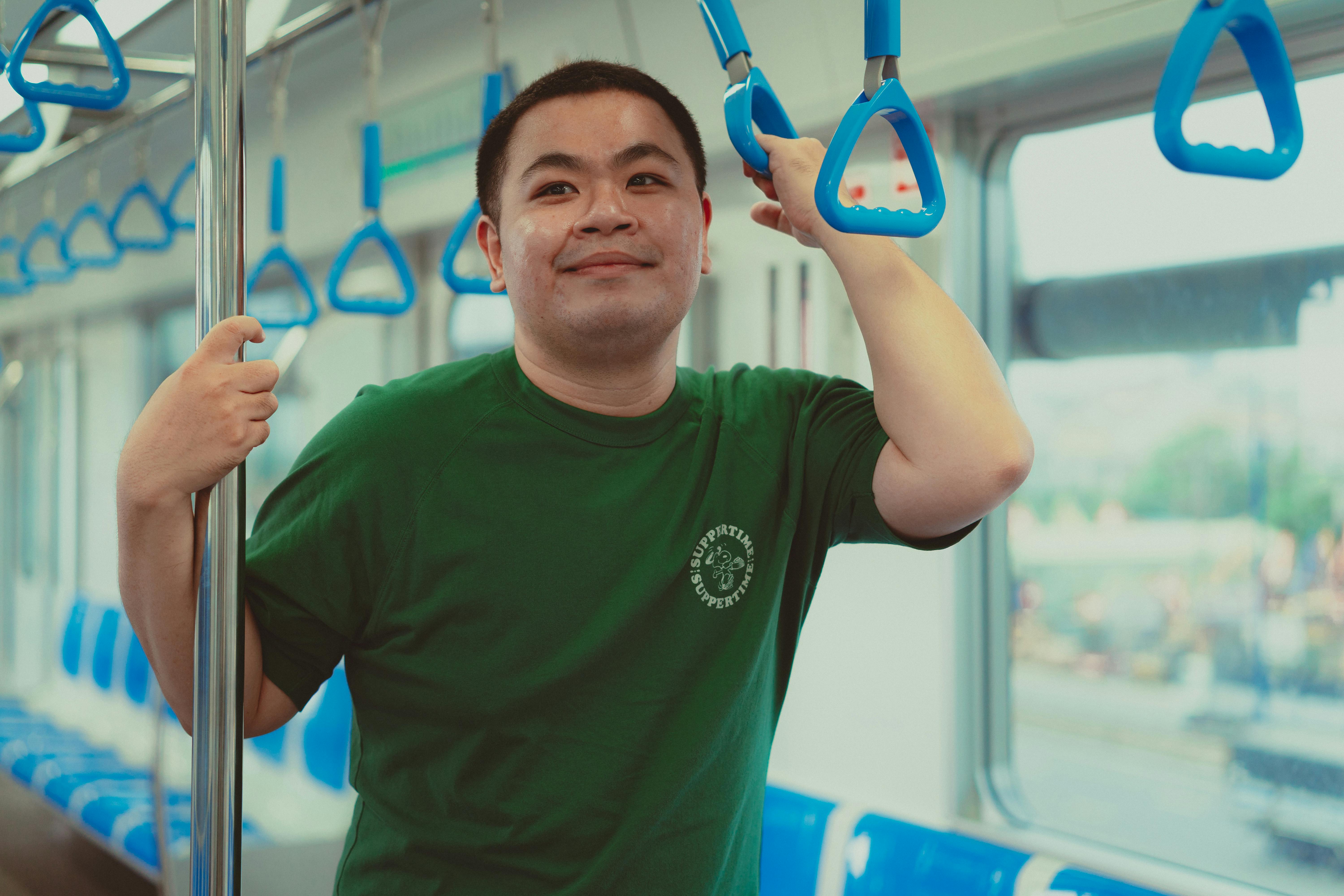 Free A man in a green shirt poses on the modern Ho Chi Minh City metro. Stock Photo