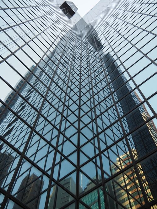 Free A towering glass skyscraper in Hong Kong reflecting the cityscape, showcasing modern architecture. Stock Photo