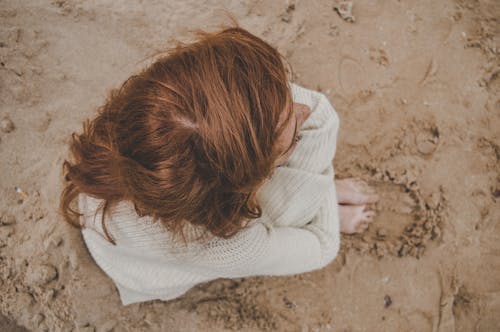 High-Angle Photo of Person Sitting on Sand