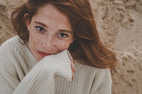 Wanita Mengenakan Sweater Rajutan Putih