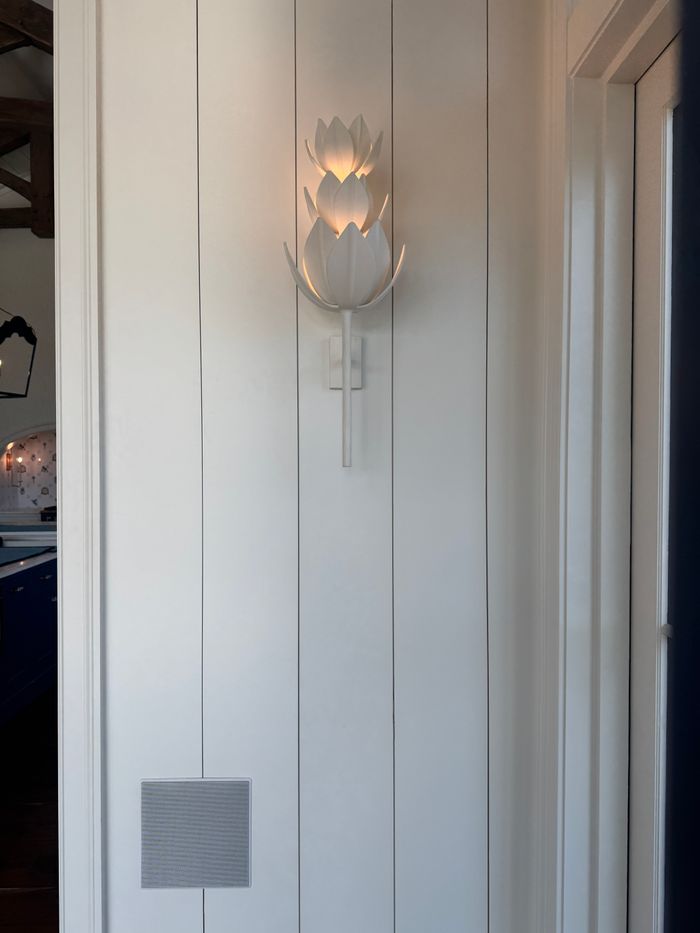 A sculpted white sconce on a pale wall — photo by Curt Hubner on Pexels