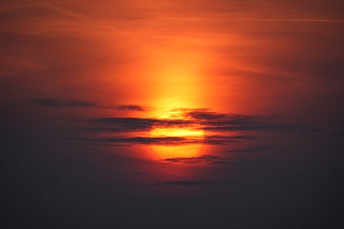 Free Capture of a dramatic sunset with vivid orange and red hues in a cloudy sky. Stock Photo