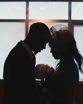 Silhouette of a couple sharing a tender moment indoors, emphasizing romance and intimacy.