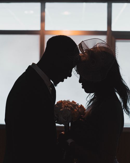 Free Silhouette of a couple sharing a tender moment indoors, emphasizing romance and intimacy. Stock Photo