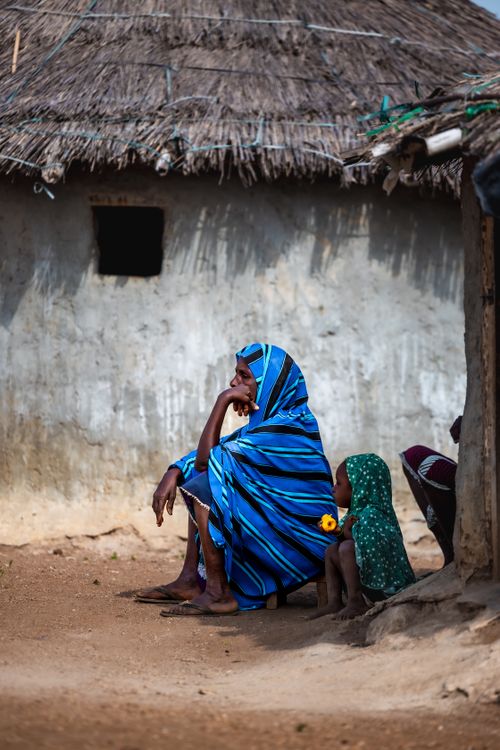 Free A vivid portrait of a family in traditional attire outside a hut in Abuja, Nigeria. Stock Photo