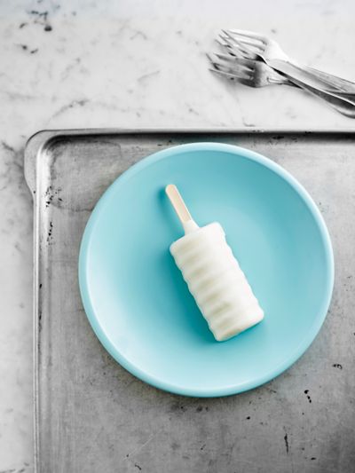 A white ice pop on a blue plate styled as a refreshing summer snack