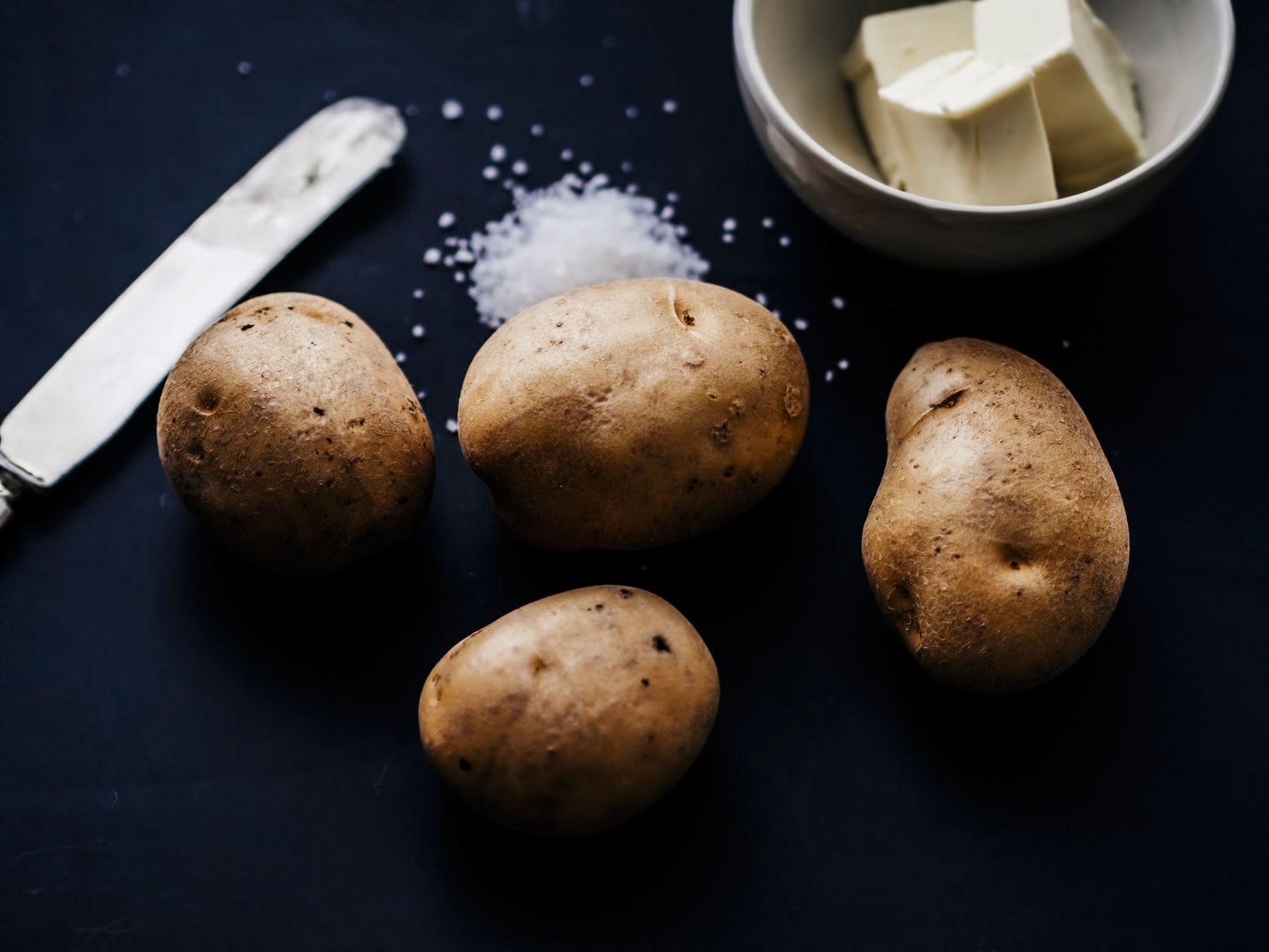Fluffy baked potato split open with butter and chives