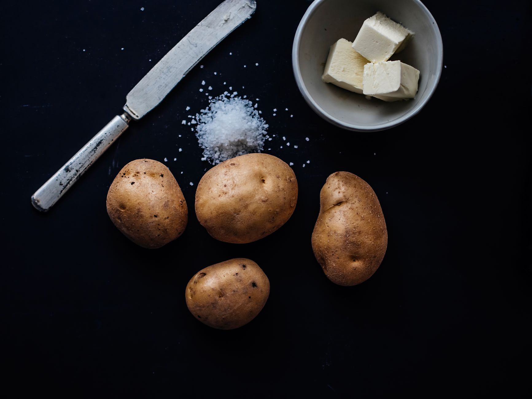 Twice baked potatoes topped with cheese and herbs on a rustic plate