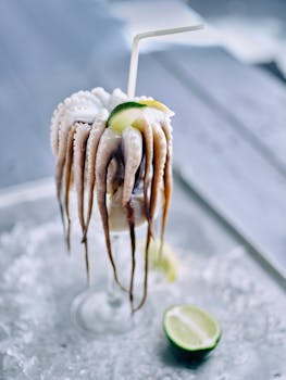 Closeup of raw octopus tentacles on ice with lime, perfect for gourmet seafood dishes.