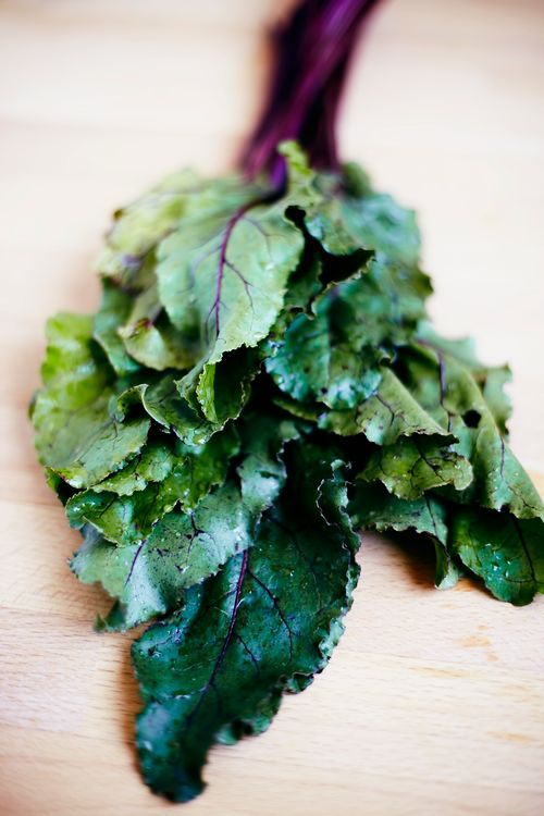 Free Close-up of fresh beet greens on a wooden surface showcasing vibrant colors. Stock Photo