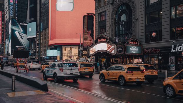 Vibrant street view of Times Square, New York City featuring taxis, billboards, and urban architecture.