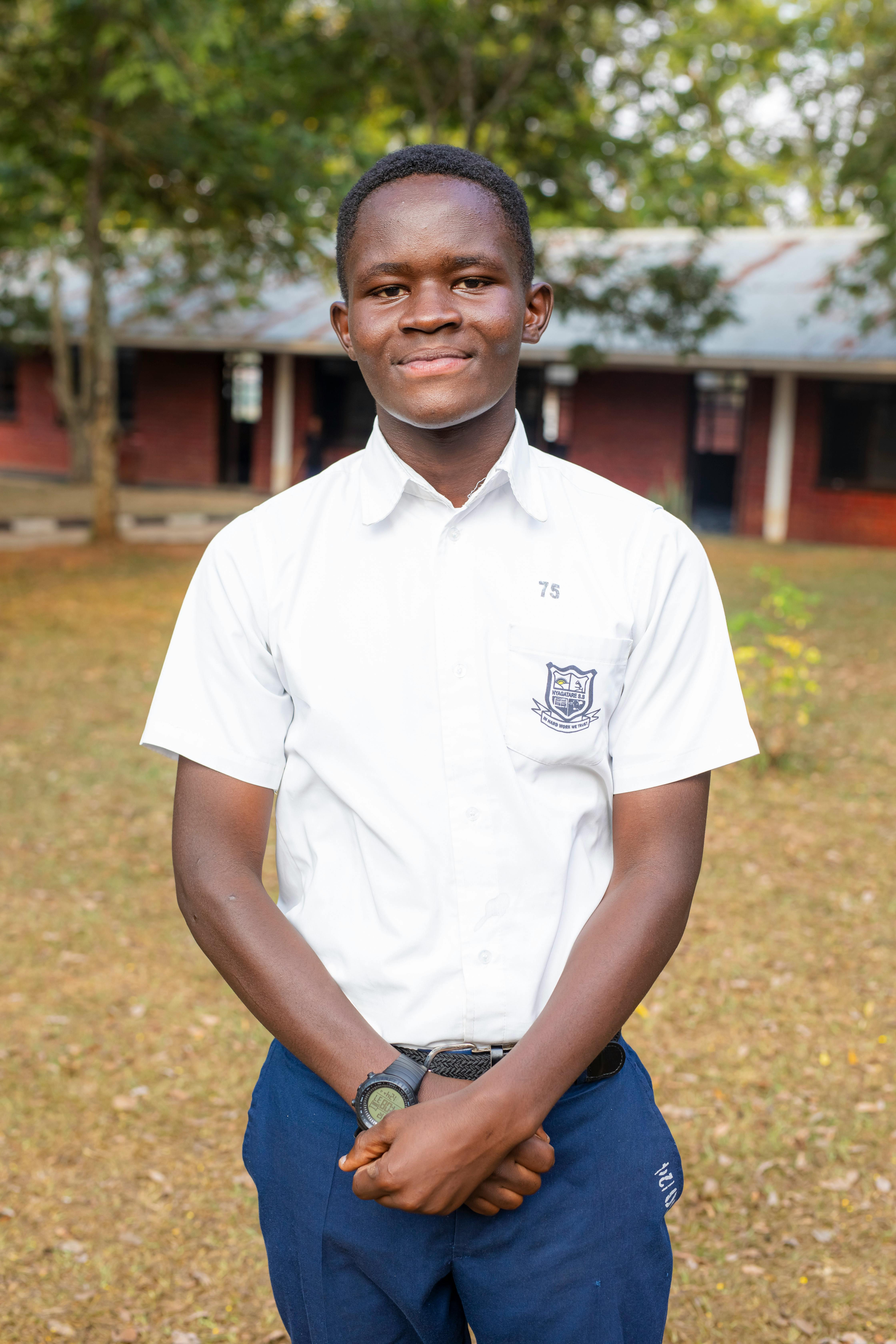Young student posing outside in a school uniform, smiling confidently.