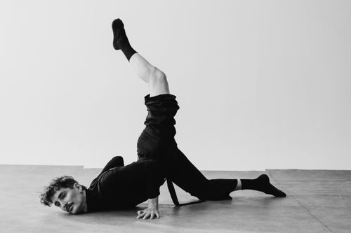 Free Black and white artistic shot of a dancer in a striking pose inside a Berlin studio. Stock Photo