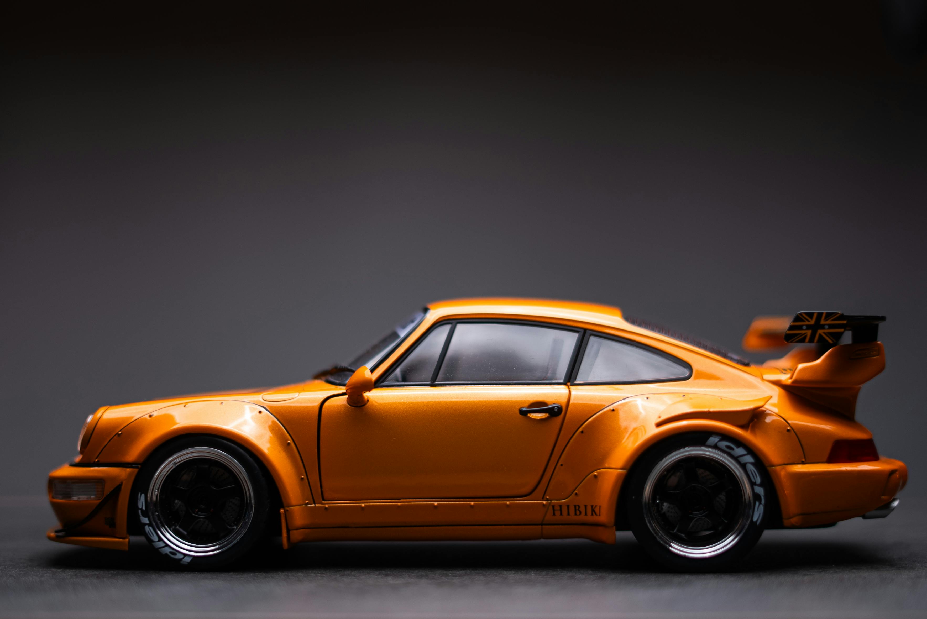 orange vintage sports car model on dark background