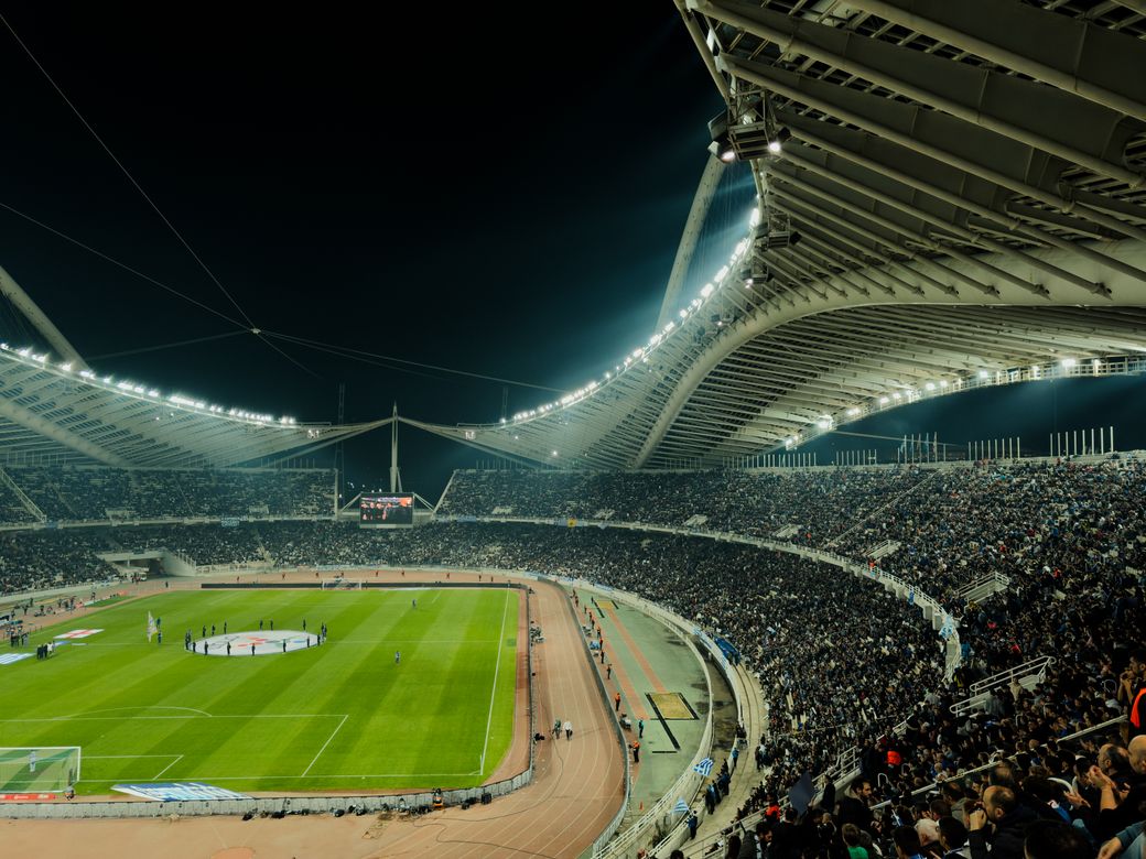 Packed stadium under floodlights at night, by George Zografidis on Pexels