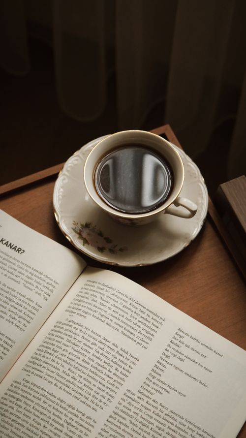 Free A serene setup with a cup of coffee and an open book, perfect for cozy mornings. Stock Photo