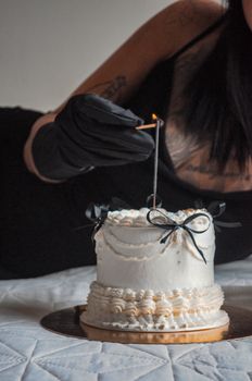 Stylish cake with a lit candle, adorned with black ribbon, perfect for celebrations.