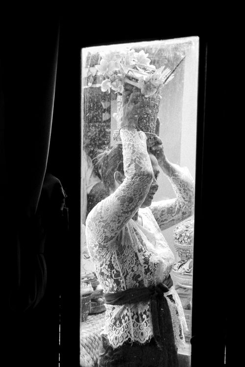 Free A woman participates in a Balinese temple ritual, holding floral offerings. Stock Photo