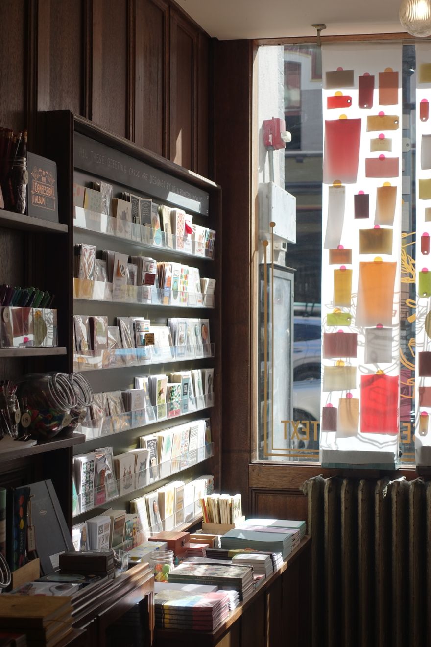 Stationery shop shelves of cards lit by a window — photo by casper lin on Pexels