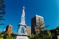 蔚蓝的天空下，一座引人注目的复制塔矗立在城市建筑与教堂之间