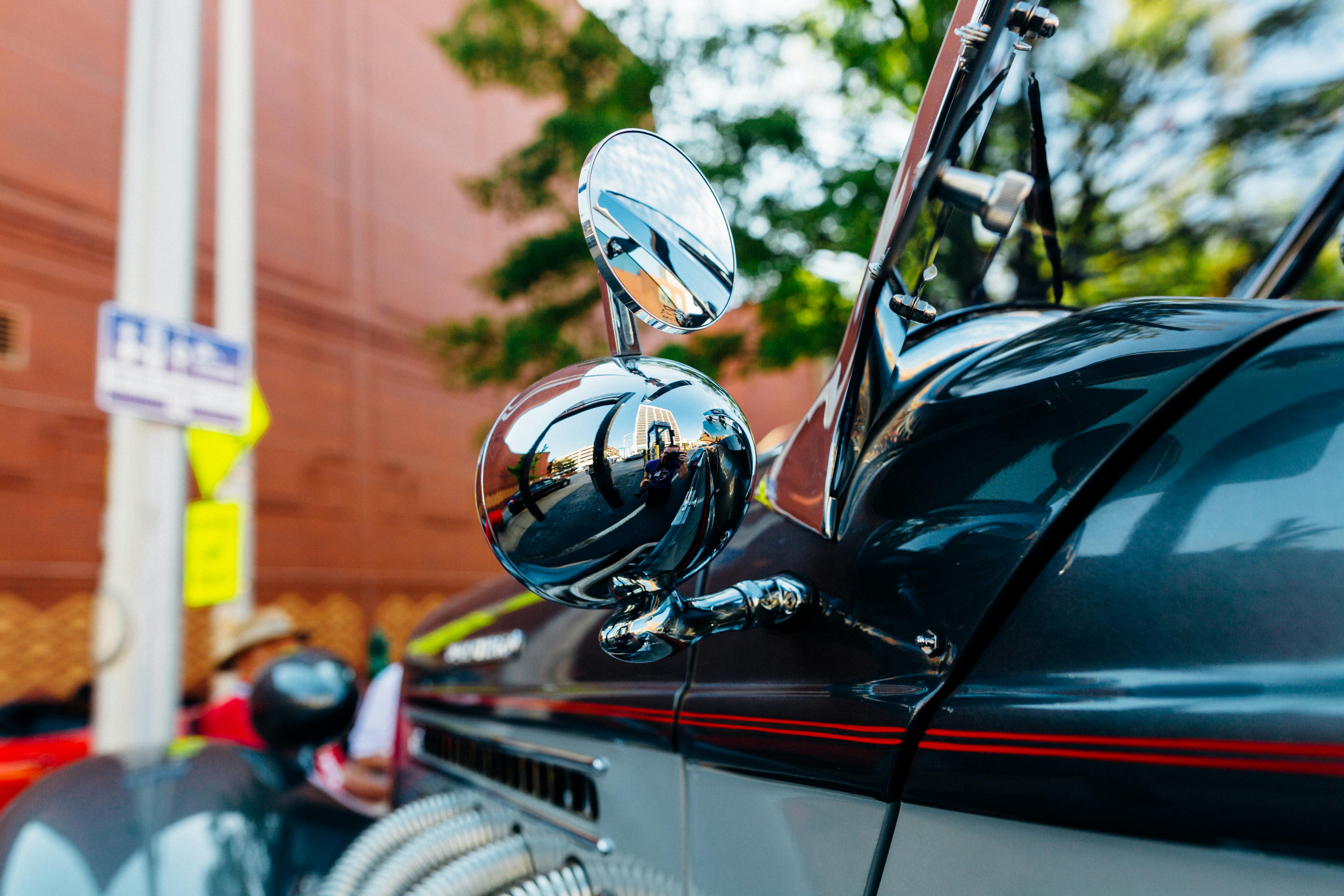 老式汽车侧镜的详细视图，展现了户外场景