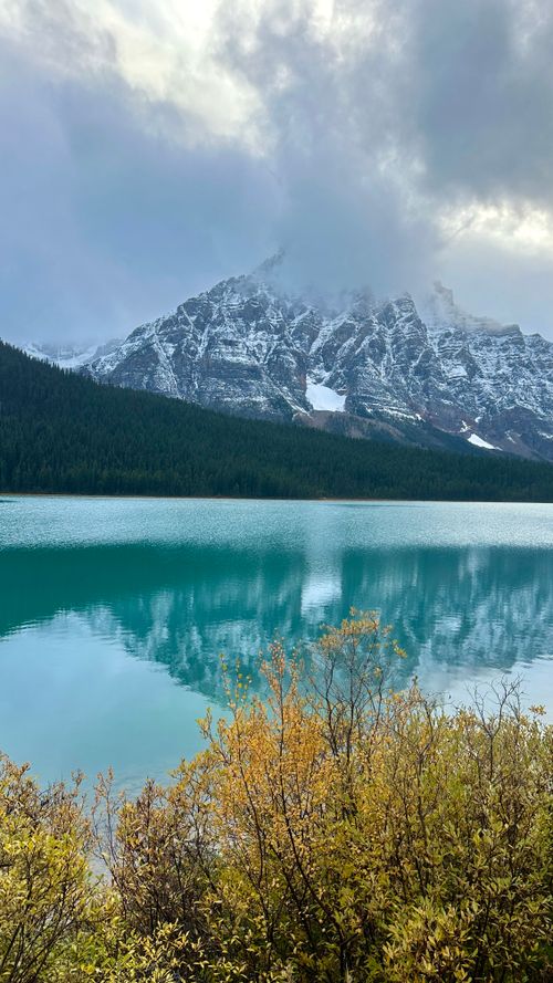 Free Breathtaking view of blue alpine lake with snowy mountains and clouds. Stock Photo