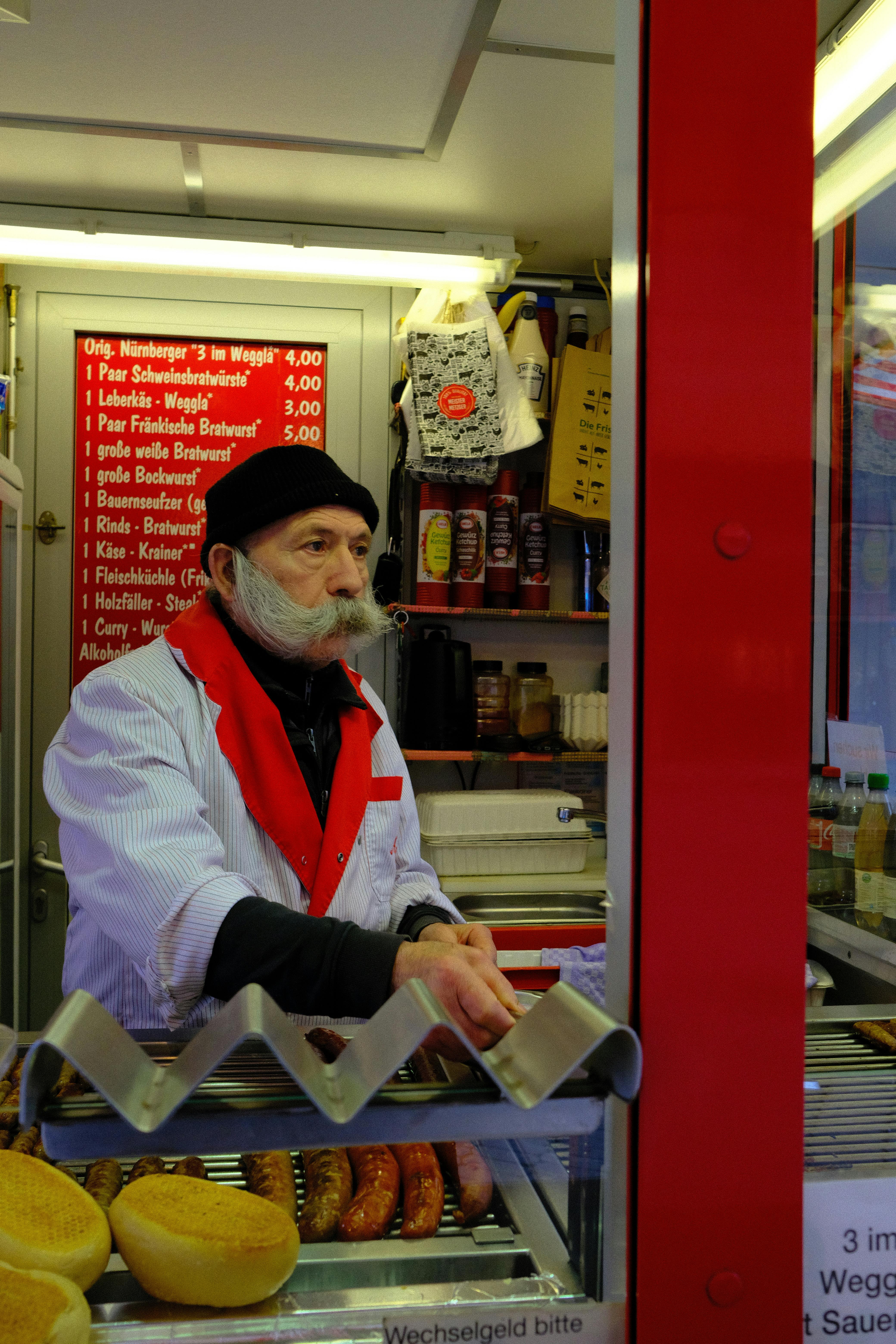 A sausagemaker in a traditional stall in Nuremberg, Germany, serving local delicacies.