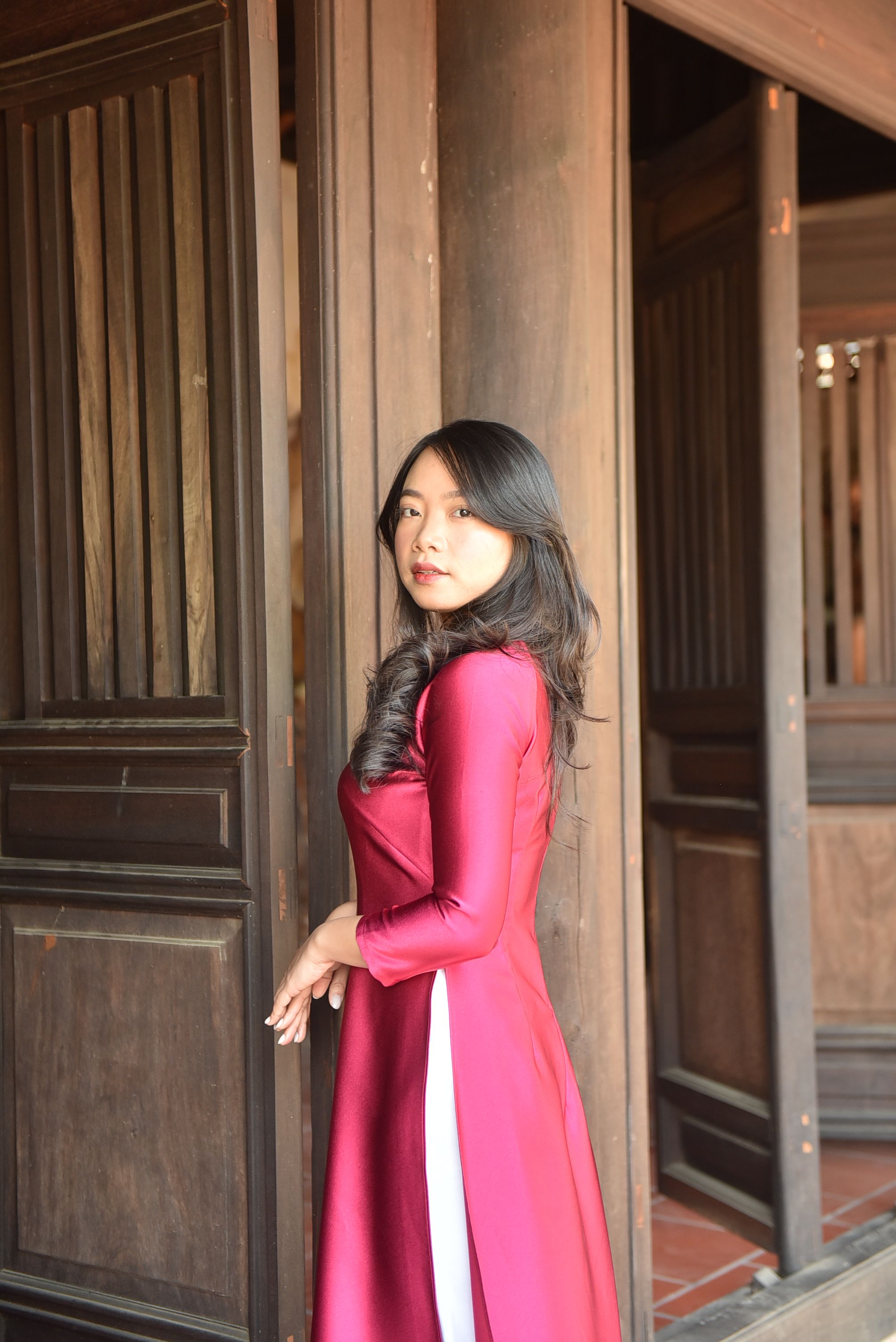 Woman in Traditional Dress Standing in Wooden Doorway · Free Stock Photo