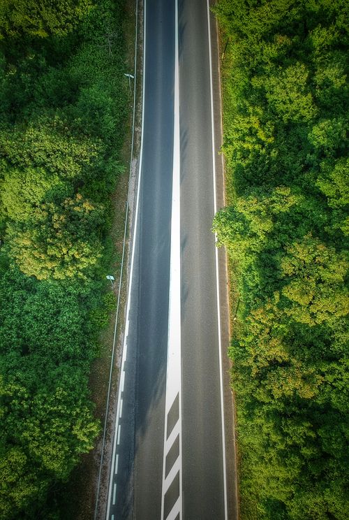 Free Drone shot of a road cutting through lush forest in Mostar, Bosnia and Herzegovina. Perfect for nature or travel themes. Stock Photo