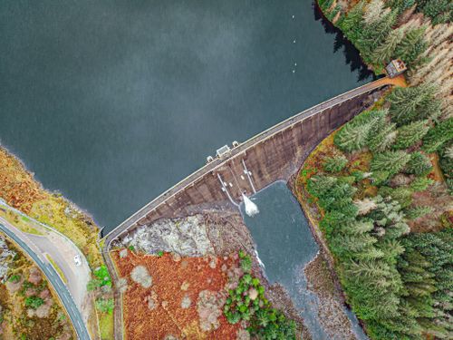 Free Stunning aerial perspective of a dam in Scotland, surrounded by lush greenery and tranquil waters. Stock Photo
