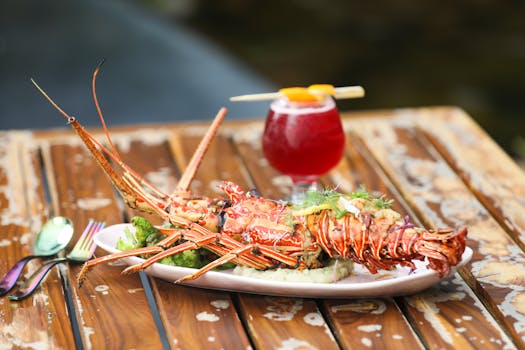 Exquisite lobster with herbs on a wooden table, paired with a refreshing cocktail in Bengaluru.