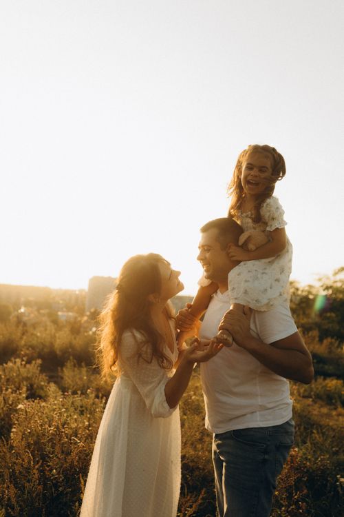 Free A joyful family enjoying a sunny day outdoors, their warm smiles reflecting the love and happiness of the moment. Stock Photo