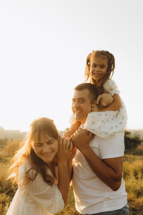 Free A joyful family spending quality time outdoors during sunset, embracing warmth and happiness. Stock Photo