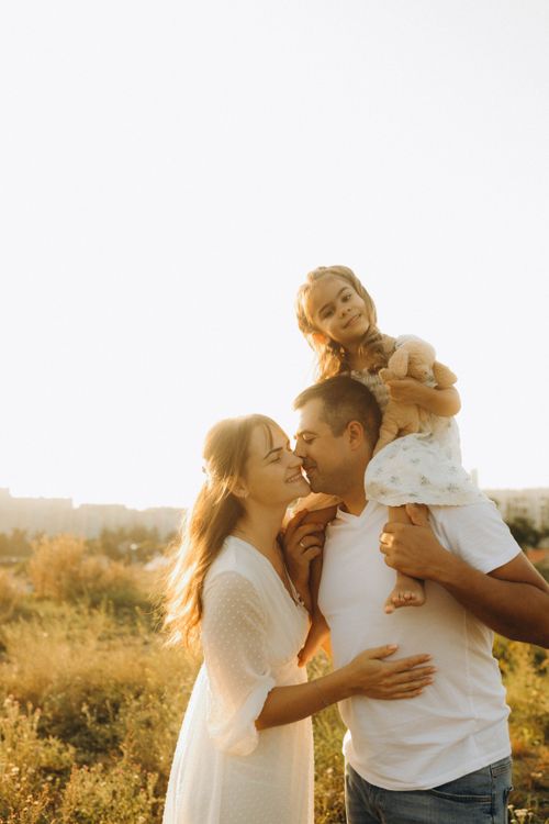 Free Family enjoying a sunny day outdoors, embracing with love and joy. Stock Photo