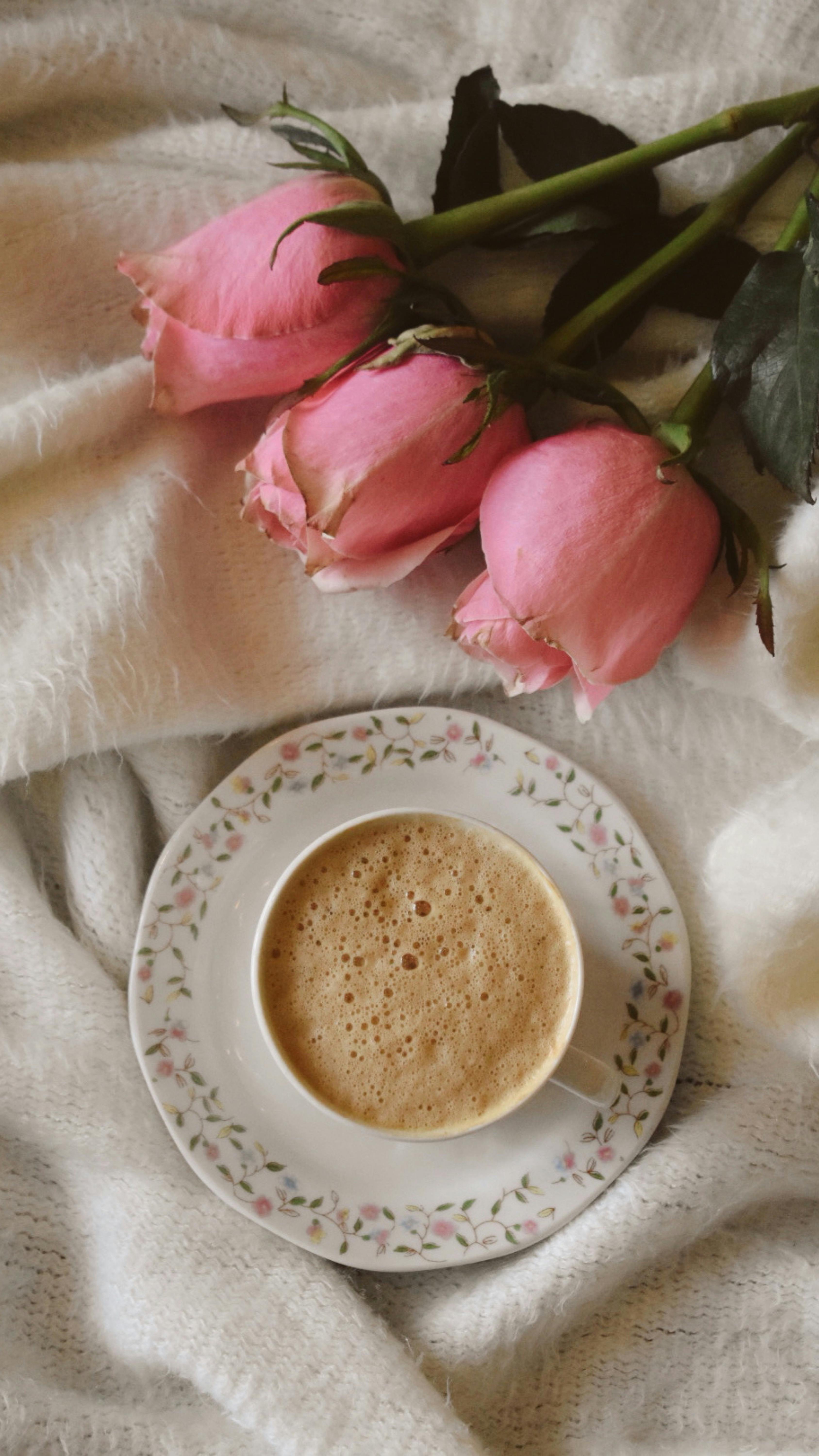 coffee cup with pink roses on soft blanket