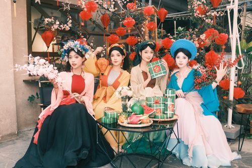 Free Elegant group in traditional outfits celebrating a festive occasion with decorations and gifts. Stock Photo