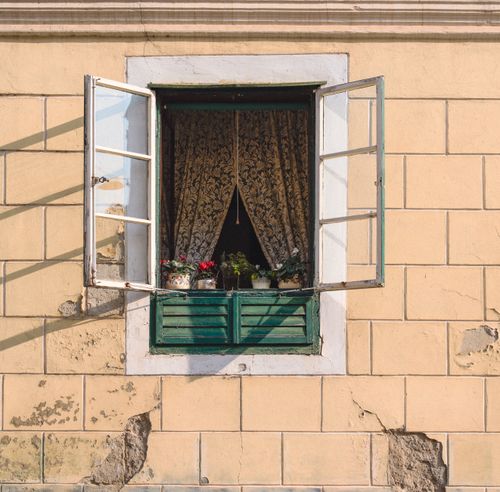 Free Charming vintage window with open shutters and floral pots, ideal for rustic decor themes. Stock Photo