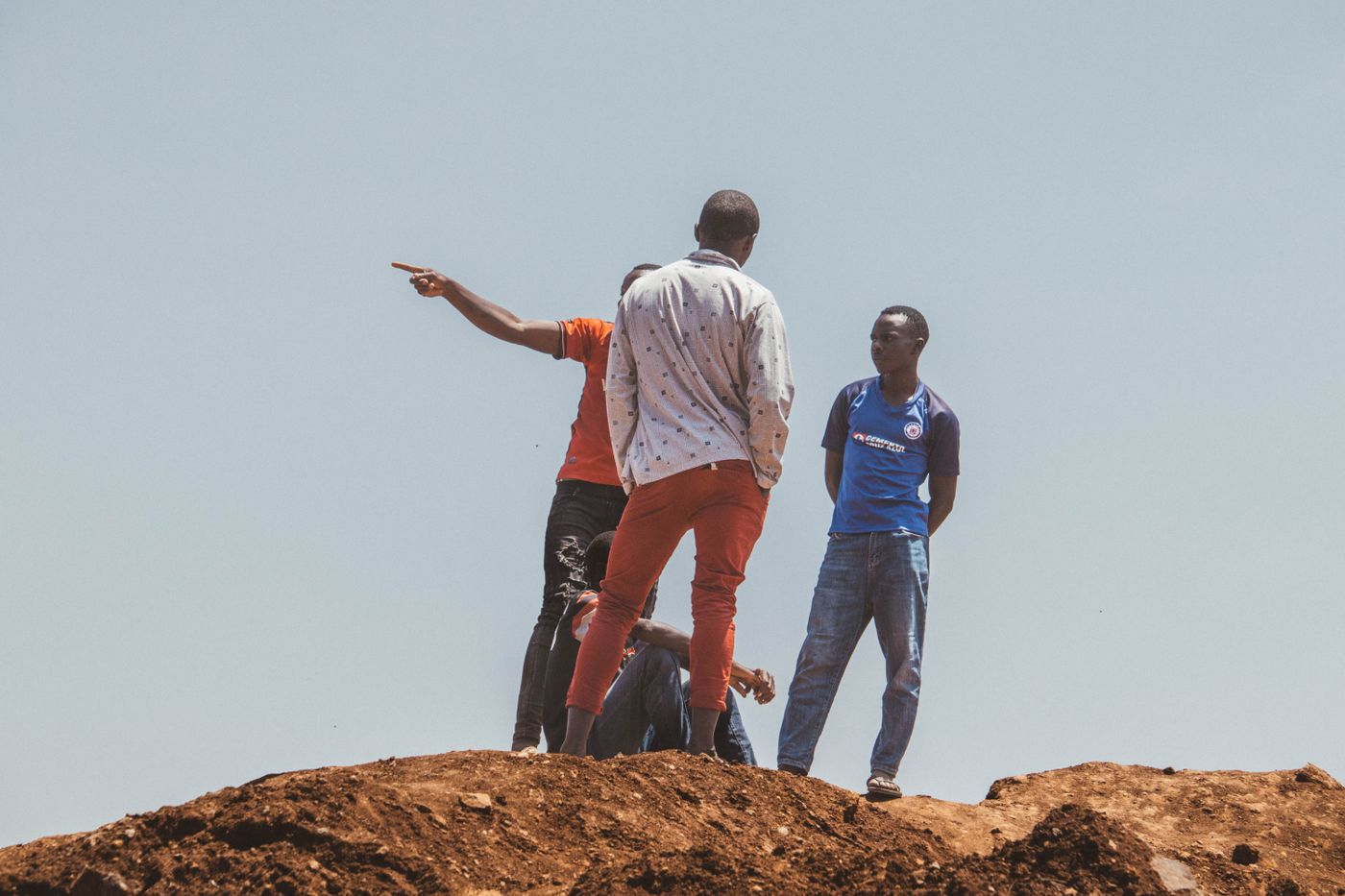 Young adults interacting on a hill in Nairobi, Kenya, during daytime.