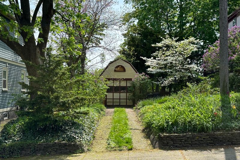 A garden path leading to a small building at the bottom of the garden