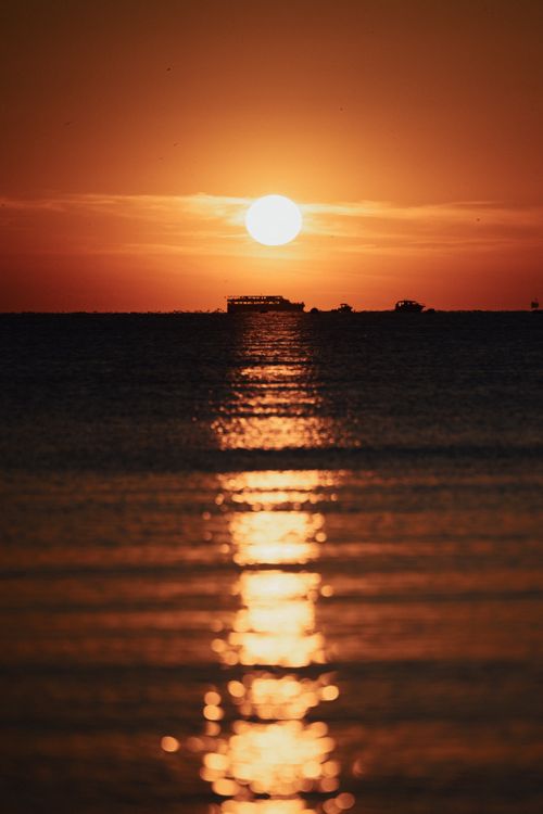 Free Captivating sunset over the sea in İstanbul with ferry silhouette and vibrant reflections. Stock Photo