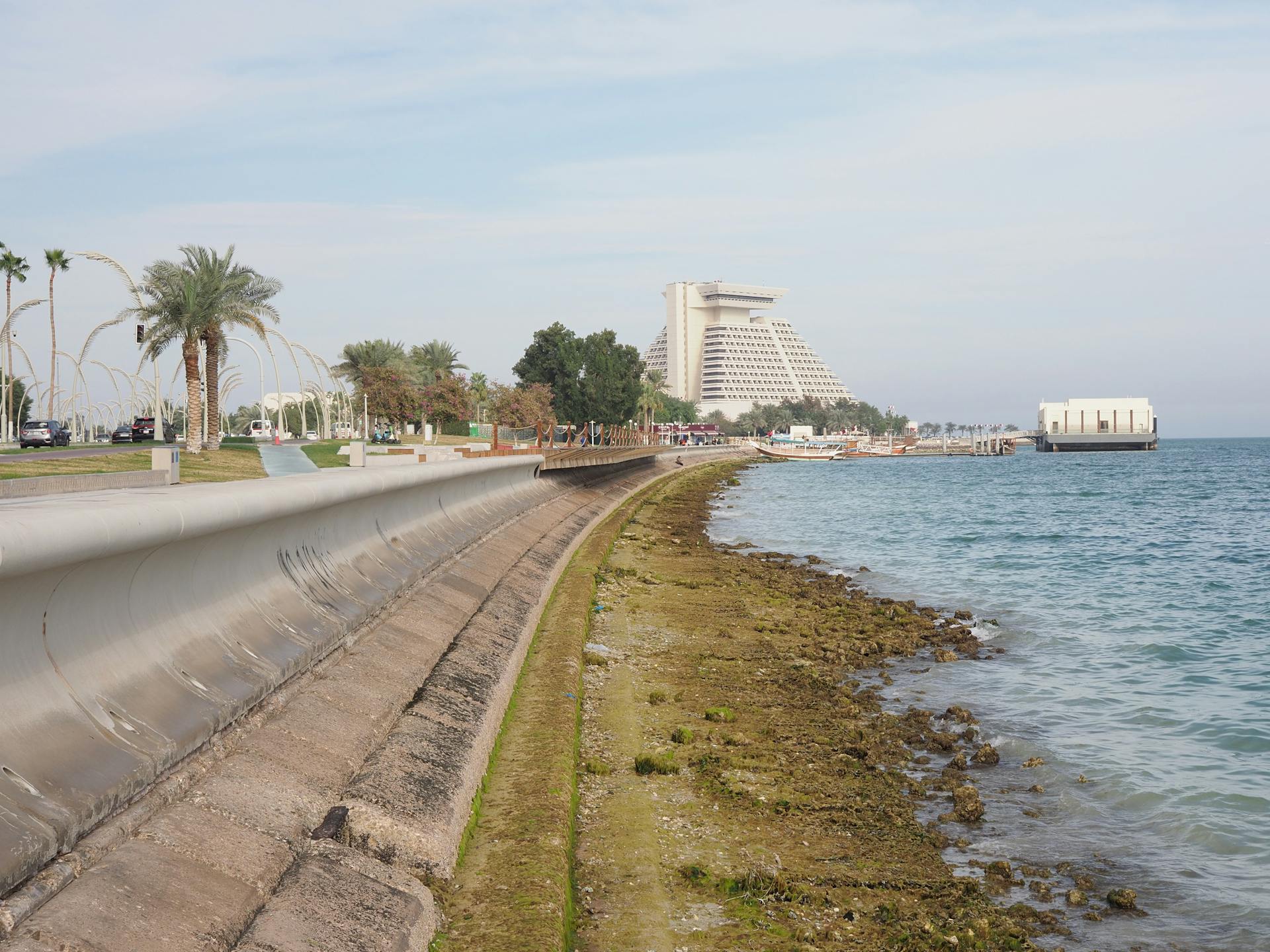 Coastal walkway with modern pyramid hotel